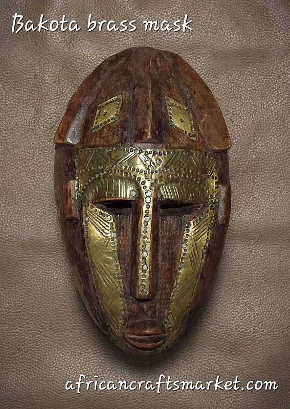 abon Kota Mbulu Ngulu brass mask, highlighting hand-hammered copper strips, intricate geometric repoussé patterns, and rich metallic patina