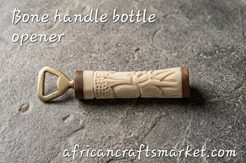 A luxury handcrafted bottle opener featuring a beautifully polished, dense African giraffe bone handle with natural cream tones, laid on a rustic wooden table 