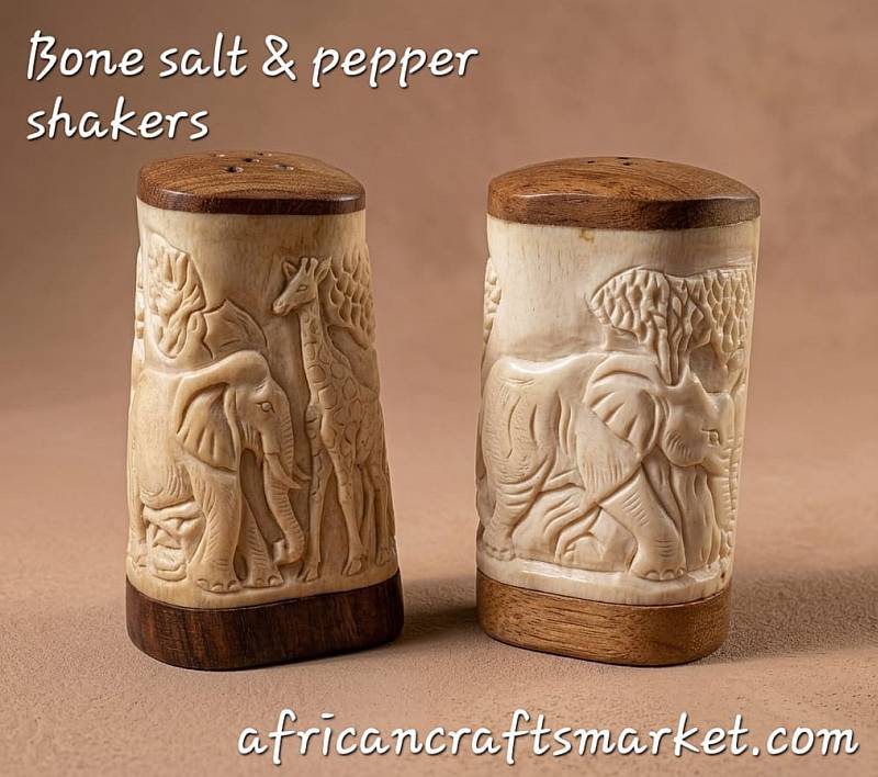 Pair of handcrafted African salt and pepper shakers made from polished cattle bone featuring intricate hand-carved batik patterns