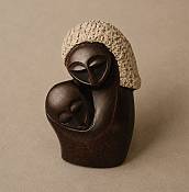 Minimalist African soapstone carving showing an abstract silhouette of a mother and child in a continuous, flowing embrace