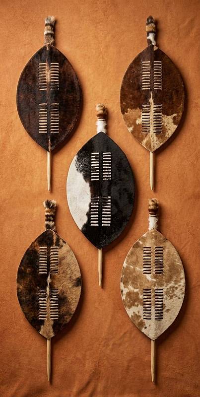 Collection of authentic Zulu dancing shields in various Nguni cattle hide patterns including brown, white, and black