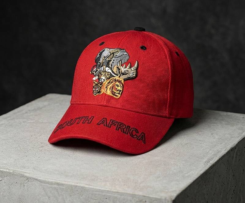 A premium red baseball cap featuring detailed embroidered Big 5 animal heads (Lion, Leopard, Buffalo, Elephant, Rhino) and 'SOUTH AFRICA' text on the brim.