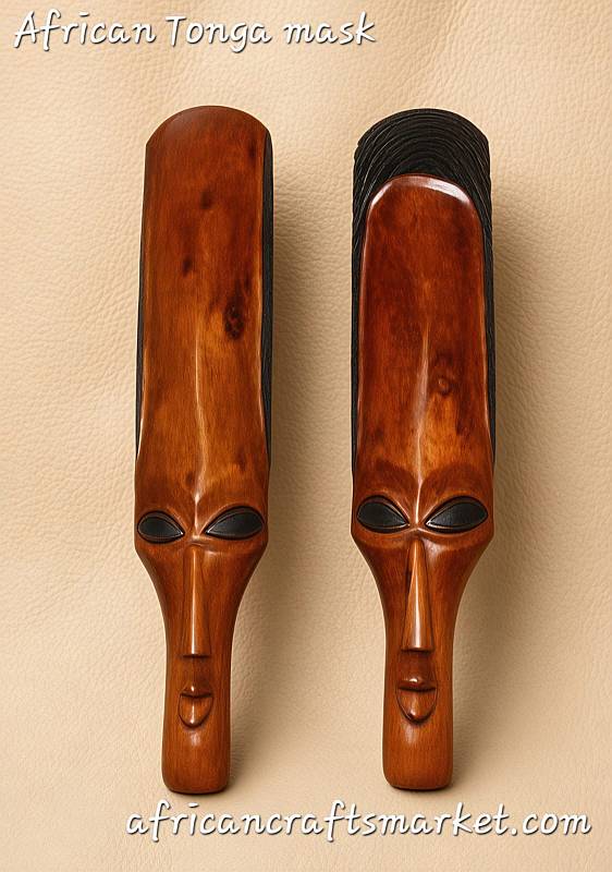Pair of long, hand-carved African Tonga tribal masks crafted from polished orange-brown ironwood by Shona artisans, showing elongated faces with distinct black-painted eyes and hair textures