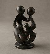 Front view of a genuine handcrafted soapstone family of four statue showcasing the natural cream and soft marble veining of the stone.