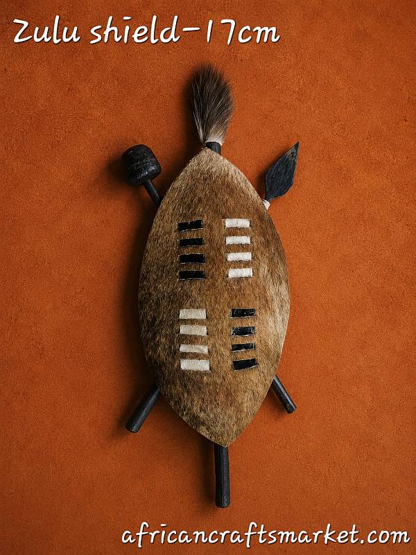 Authentic 17 cm Zulu cowhide shield featuring natural Nguni cattle hide patterns and a central wooden display staff
