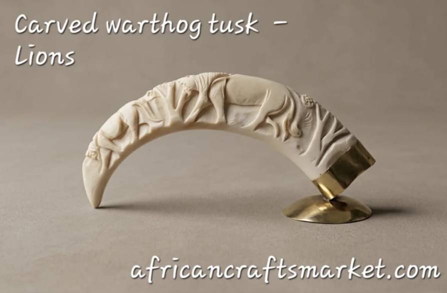 Legally sourced genuine warthog tusk fine art piece showcasing traditional local hand-carving and a detailed wildlife lion scene.