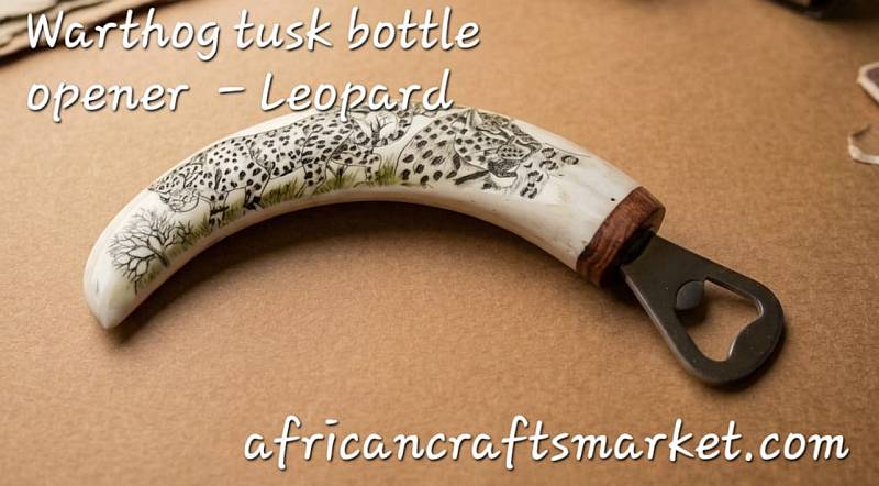 Detailed black ink scrimshaw of a leopard’s face etched onto a polished genuine African warthog tusk bottle opener